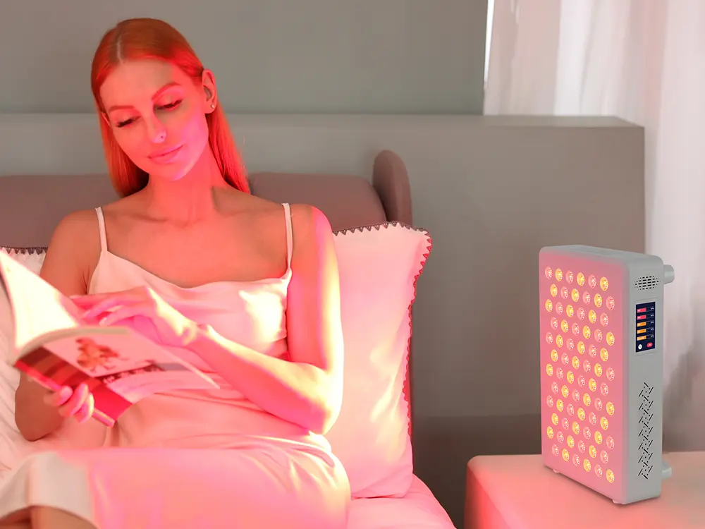 woman using red light therapy panel at home relaxing environment