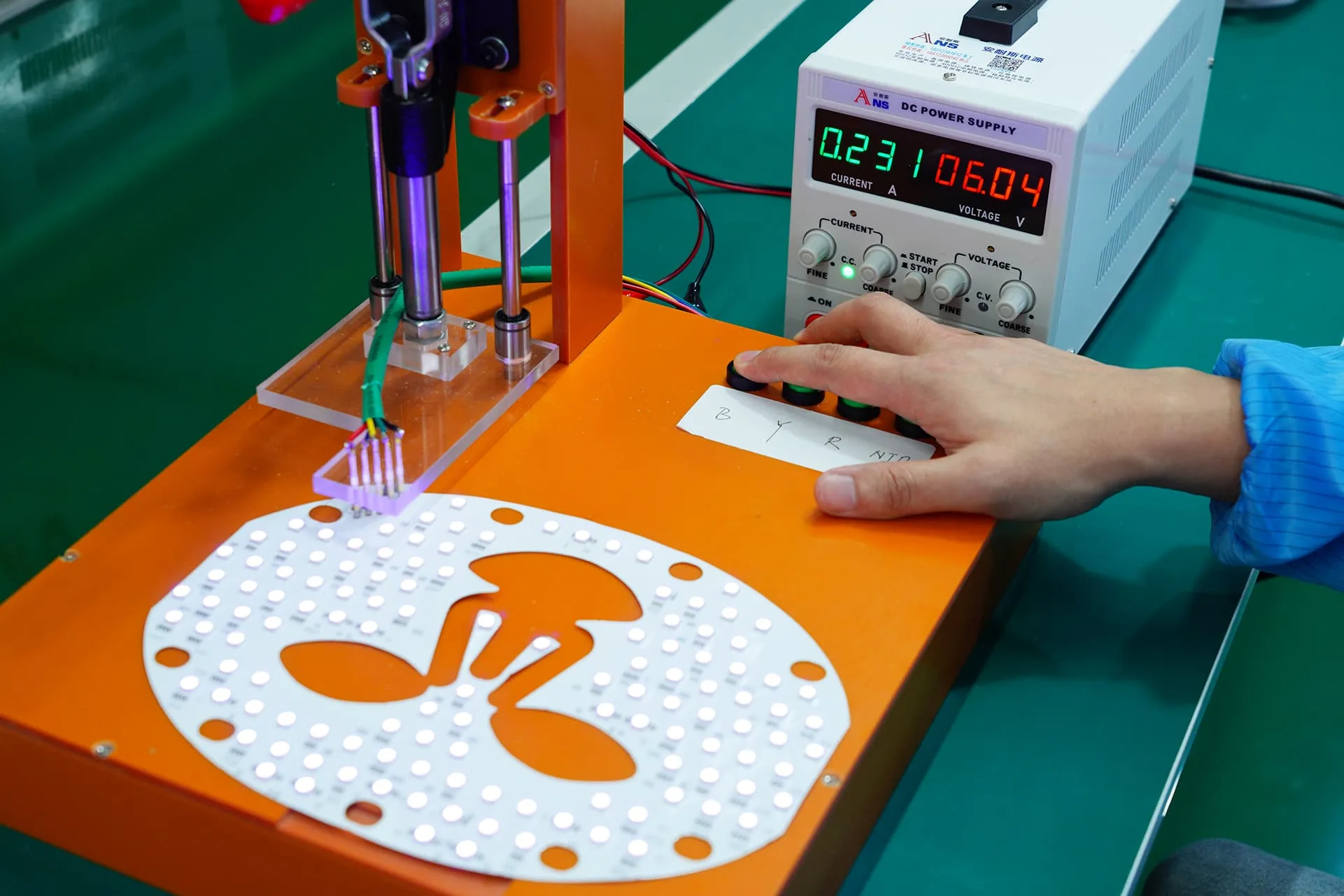 Wakelife Beauty technician testing an LED light therapy mask PCB during medical-grade red light therapy device production.