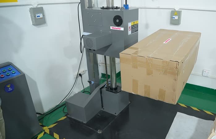 WAKELIFE packaging drop test machine used to test carton durability for red light therapy device shipments.