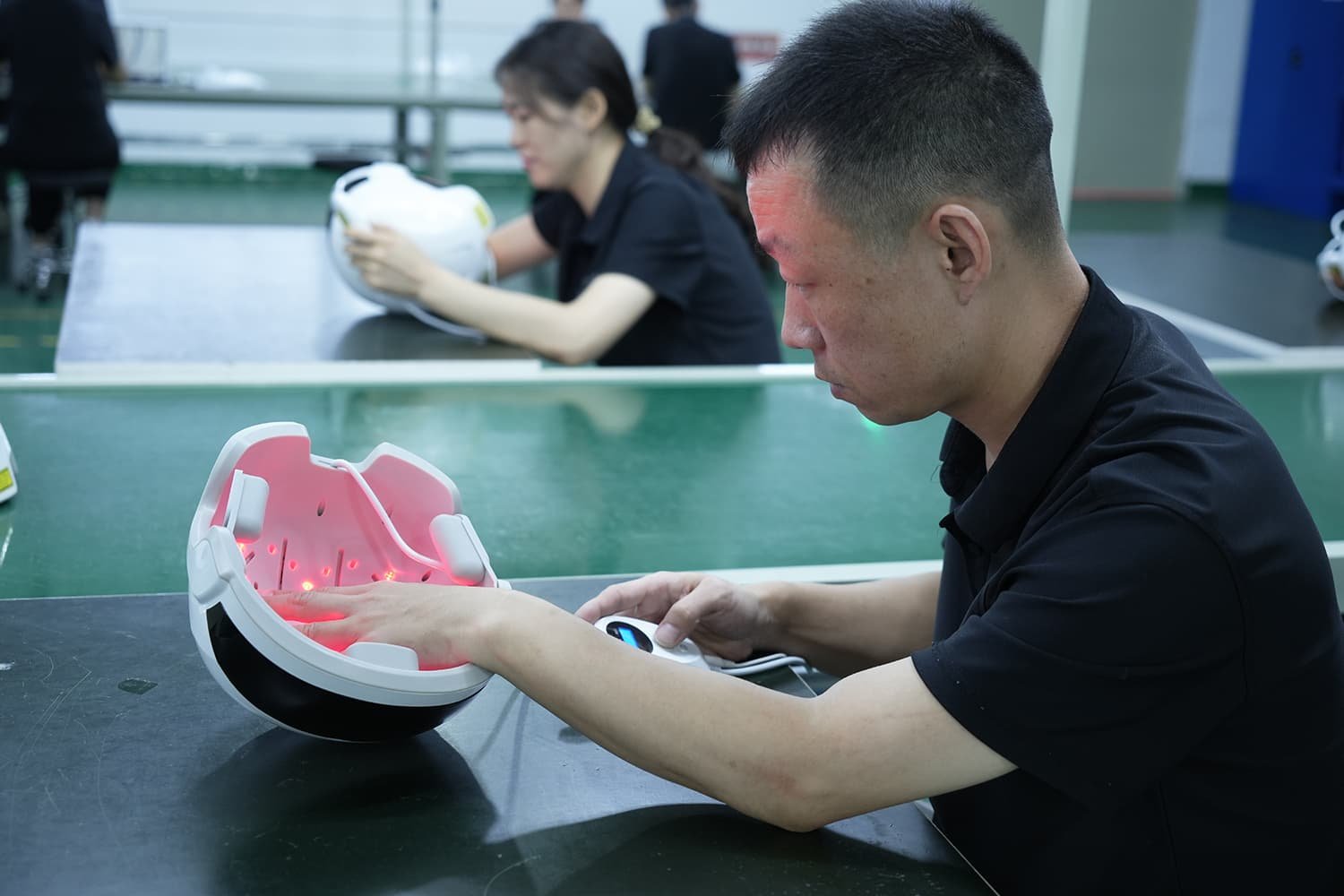 Operator inspecting VCSEL laser array in silicone hair growth cap