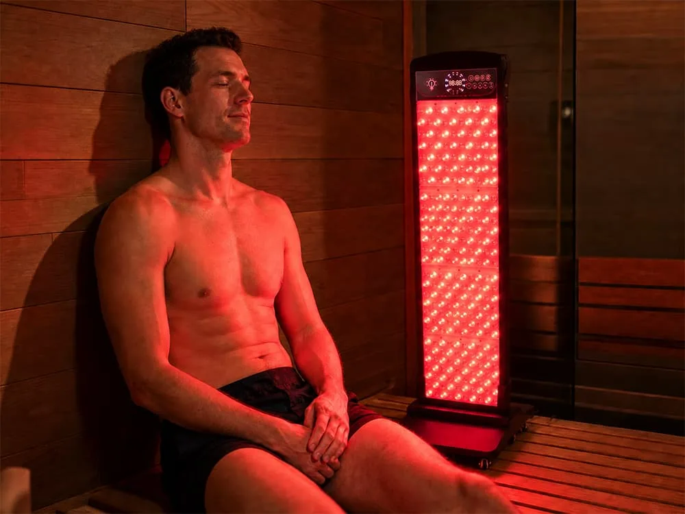 Wakelife SL280 sauna red light panel beside a man during a sauna wellness session